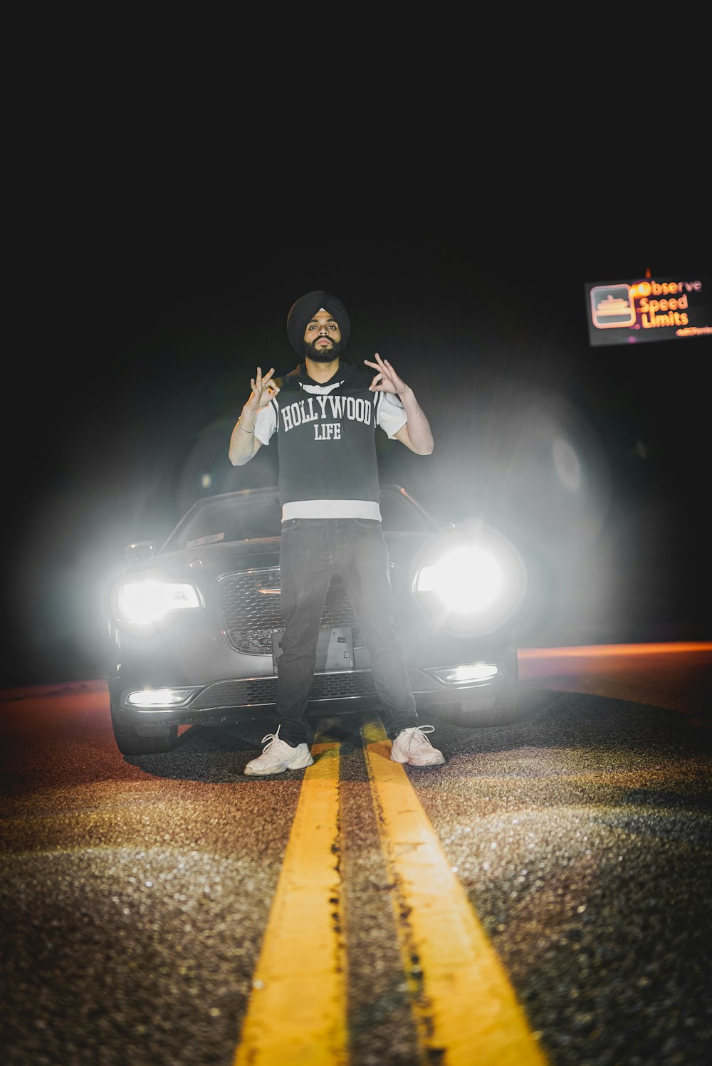 a man standing in front of a car on a road