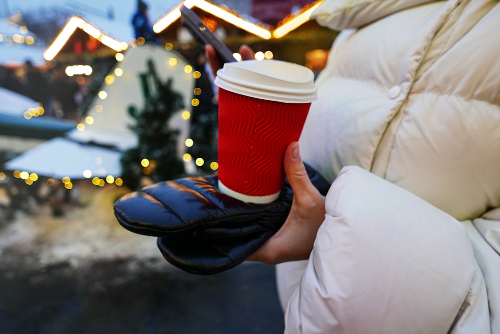 a person holding a cup of coffee in their hand