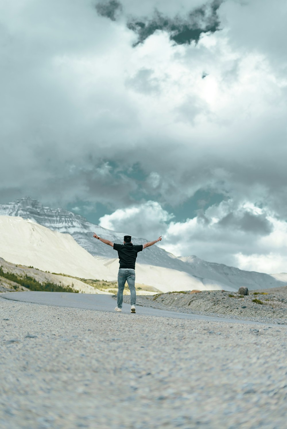 a man standing in the middle of a road with his arms outstretched