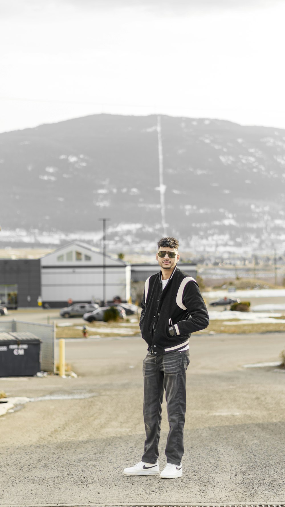 a man standing in the middle of a parking lot