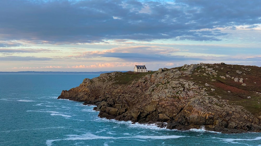 a house on top of a rocky outcropping by the ocean