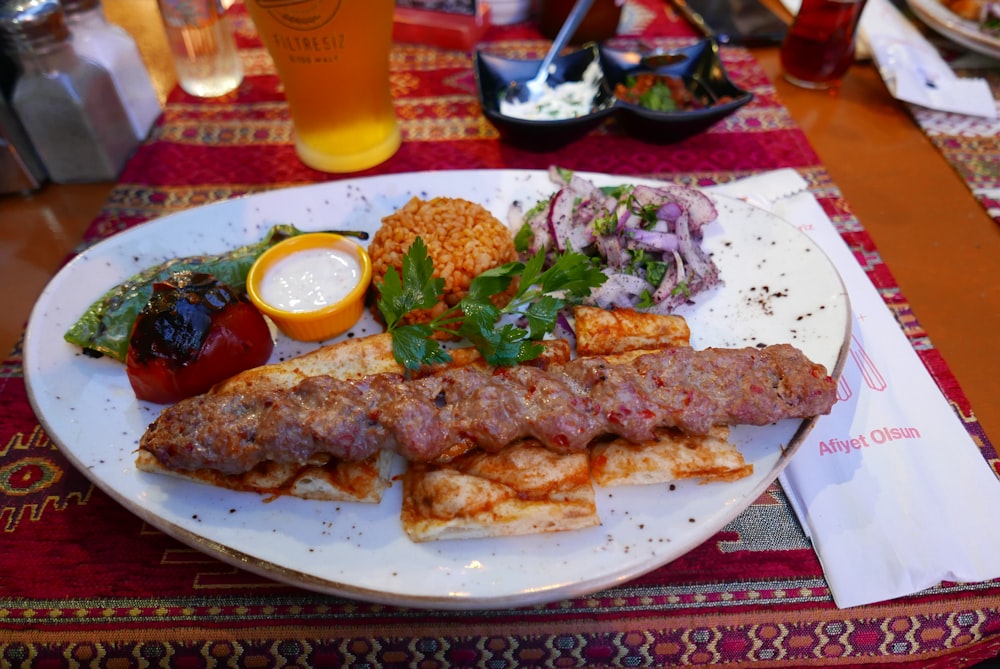 a white plate topped with meat and vegetables