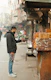 a man standing on the side of a street holding a camera