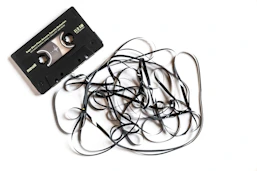 a pile of black cords next to a cassette