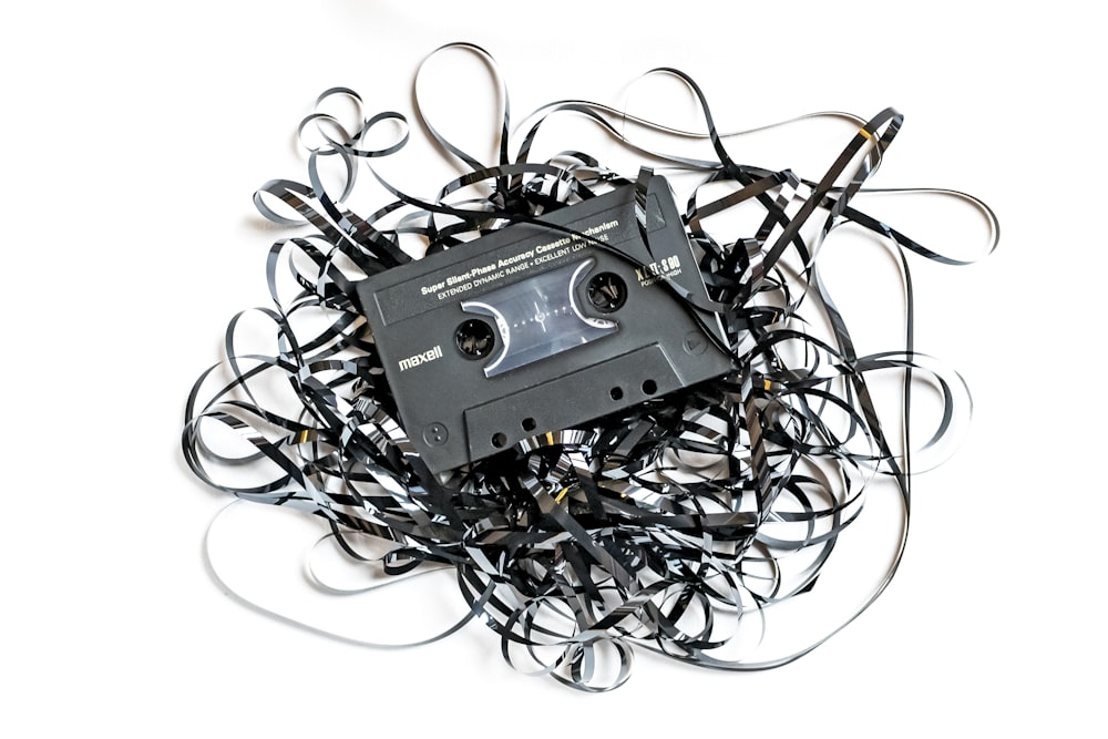 a pile of black and white wires and a cassette