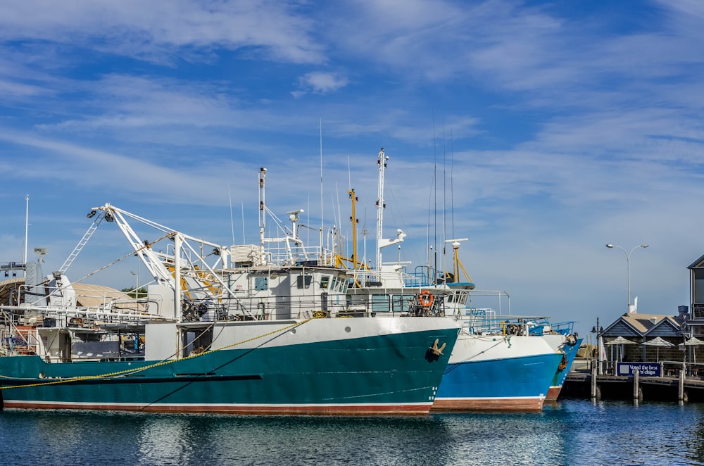 a blue and white boat docked in a harbor