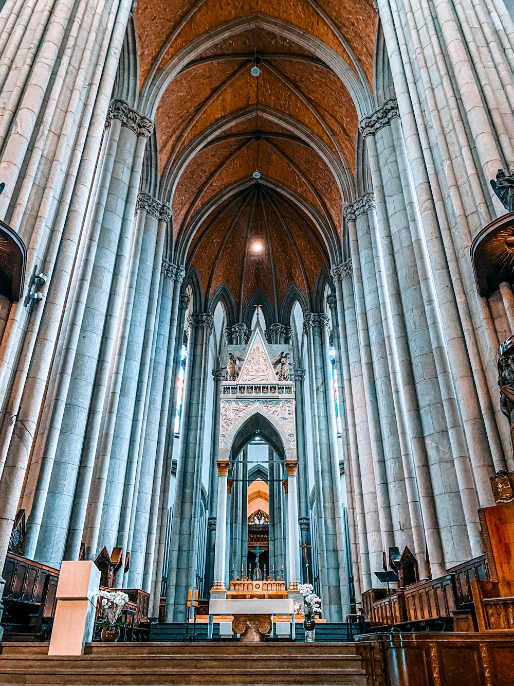 a large cathedral with pews and a man sitting at the alter
