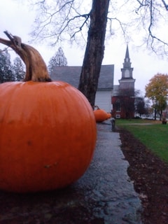 A warm autumn scene outside Laurencekirk church with pumpkins and colorful leaves.