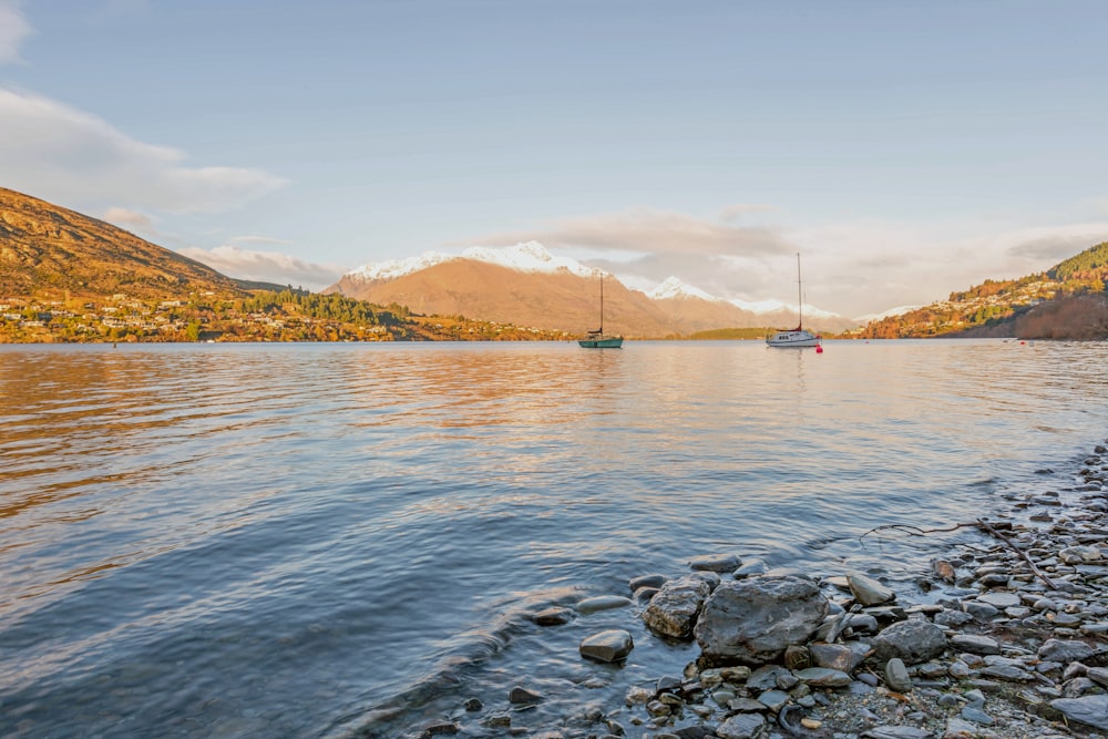 a boat on a lake with mountains in the background