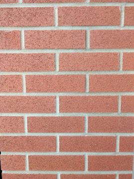 A pattern of evenly spaced red bricks with light gray mortar in between. The bricks are arranged in a horizontal alignment, creating a classic brick wall appearance.