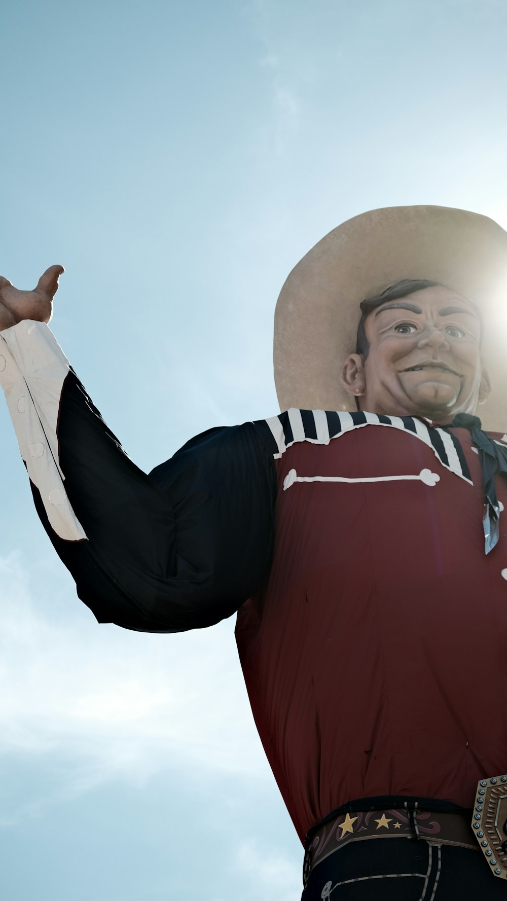 a man wearing a cowboy hat and holding his arms out