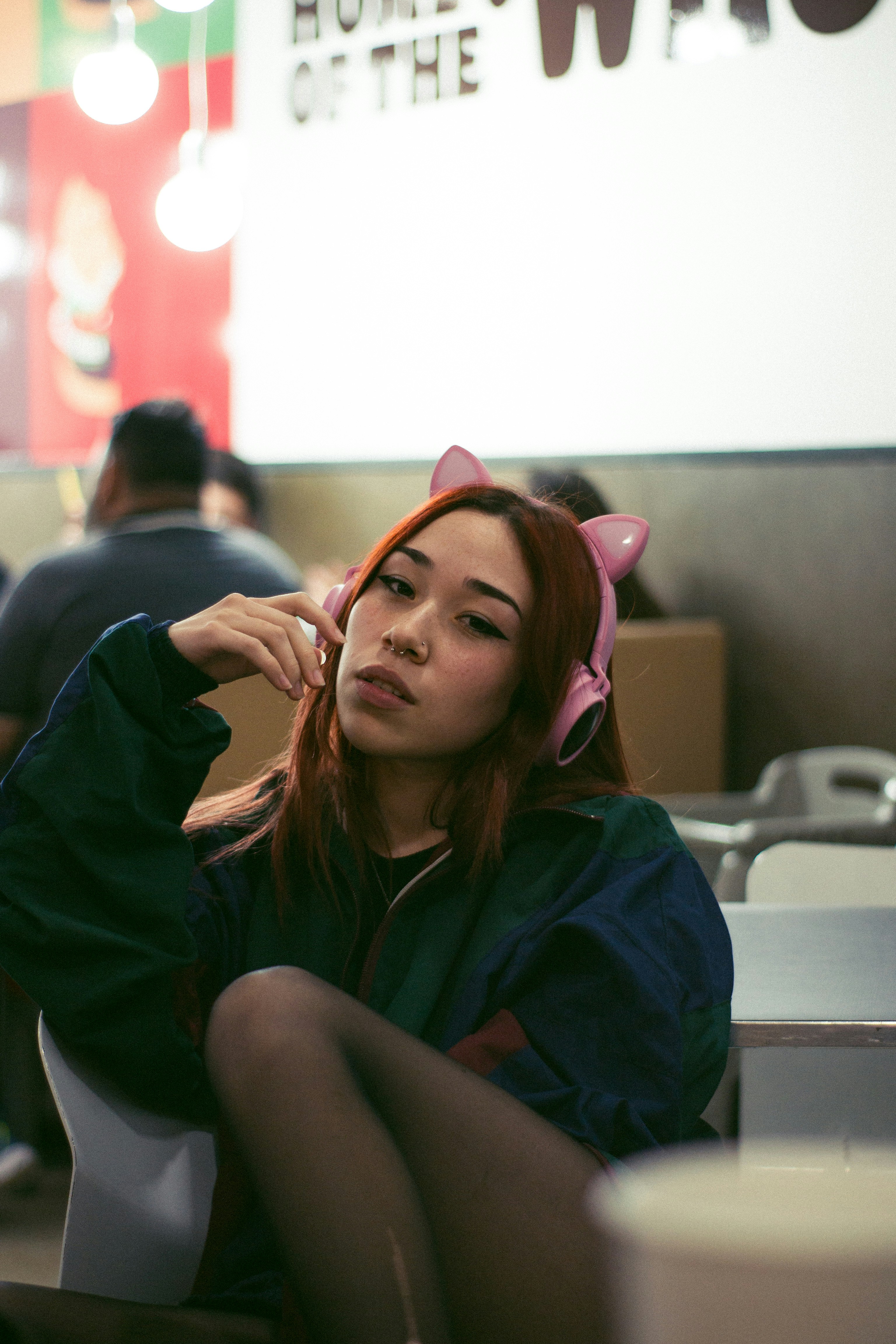 Seorang wanita duduk di bilik mengenakan headphone