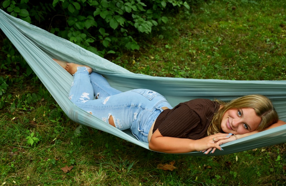 a woman laying in a hammock in the grass
