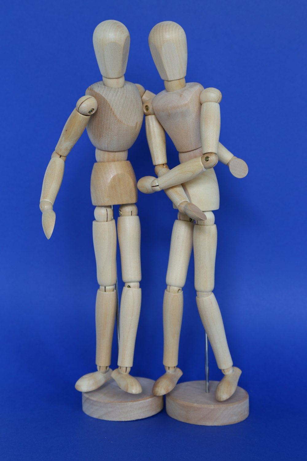 a couple of wooden mannequins standing next to each other