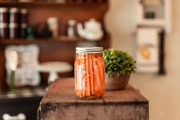 A jar of pickled carrots sitting on a table