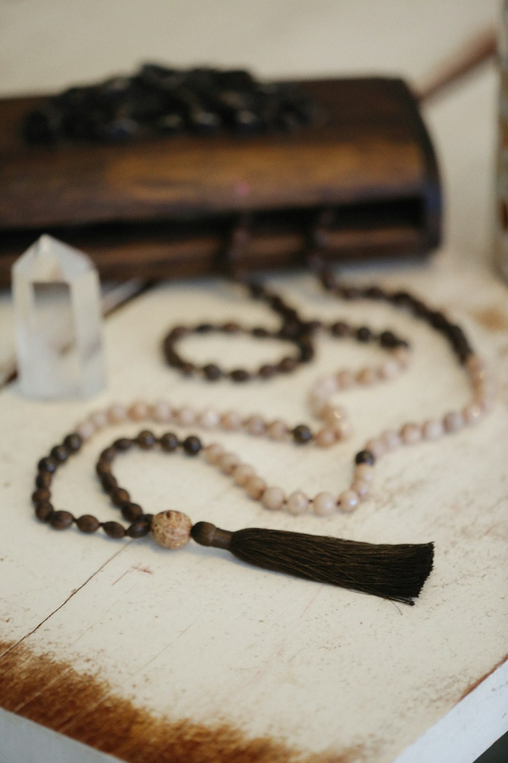 a rosary with a tassel and a candle on a table