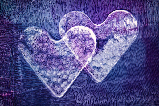 Mystical image of intertwined golden hearts with subtle purple and blue cosmic hues.