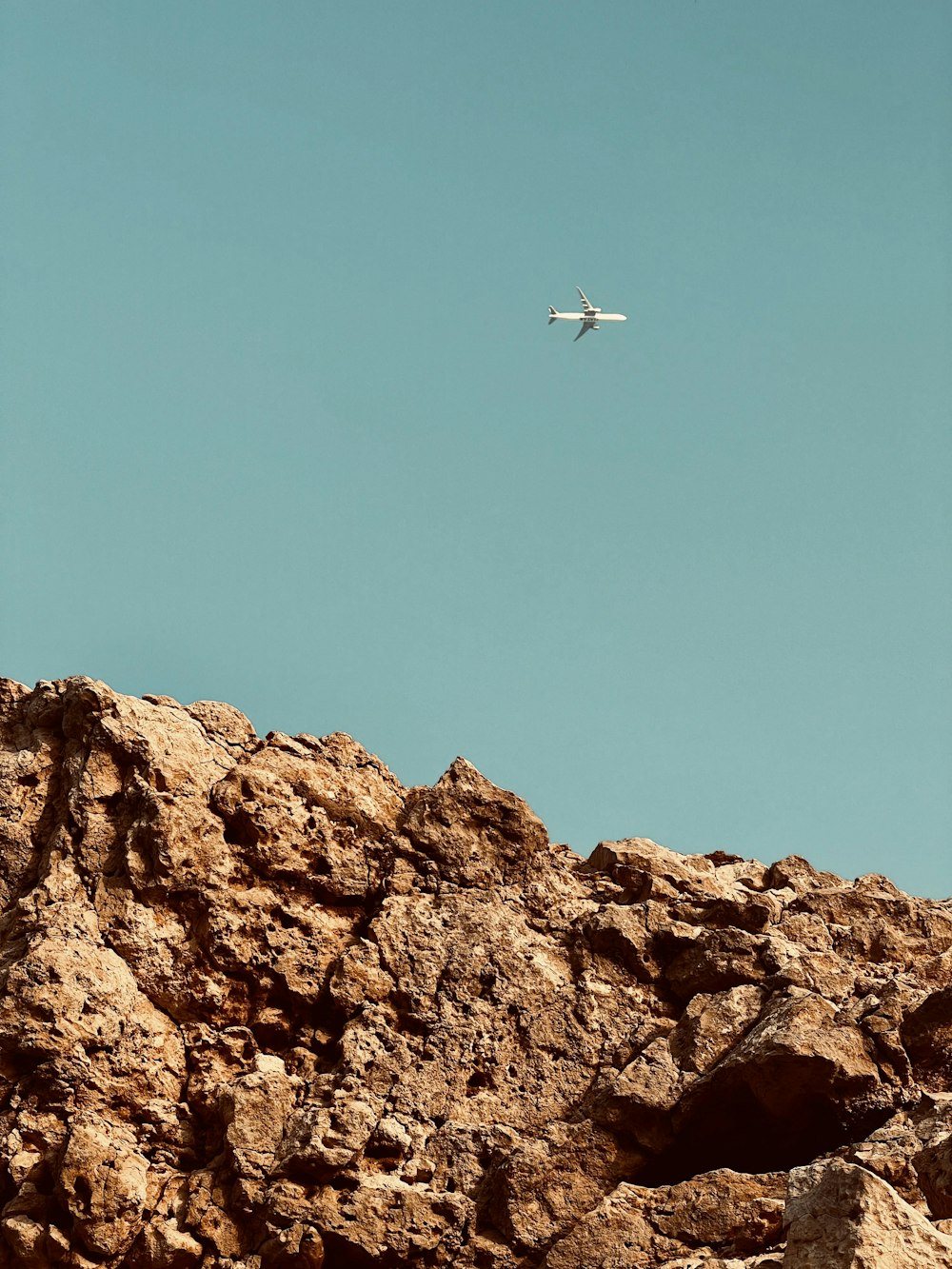 an airplane is flying over a rocky area