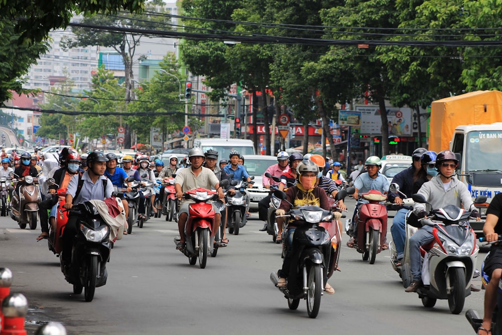 a group of people riding motorcycles down a street