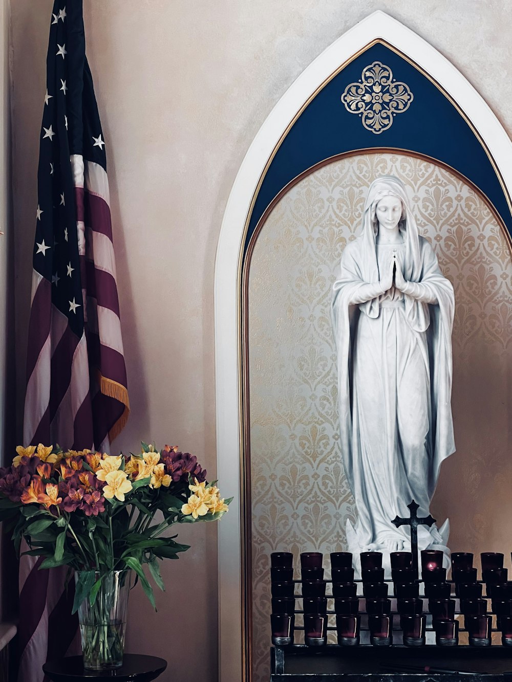 a statue of the virgin mary in front of a mirror