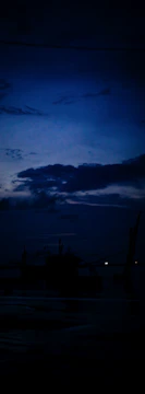 A ghostly ship silhouette fades into dark, misty ocean waters beneath a crescent moon.