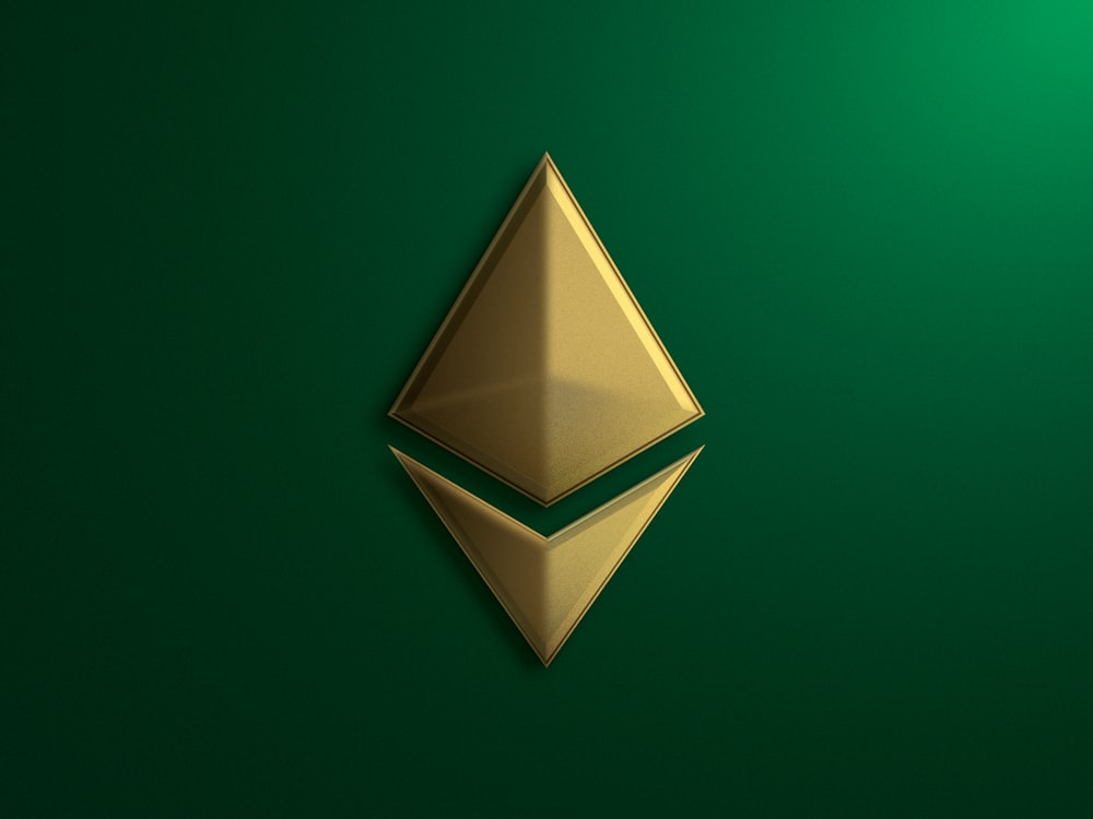 a shiny gold object on a green background