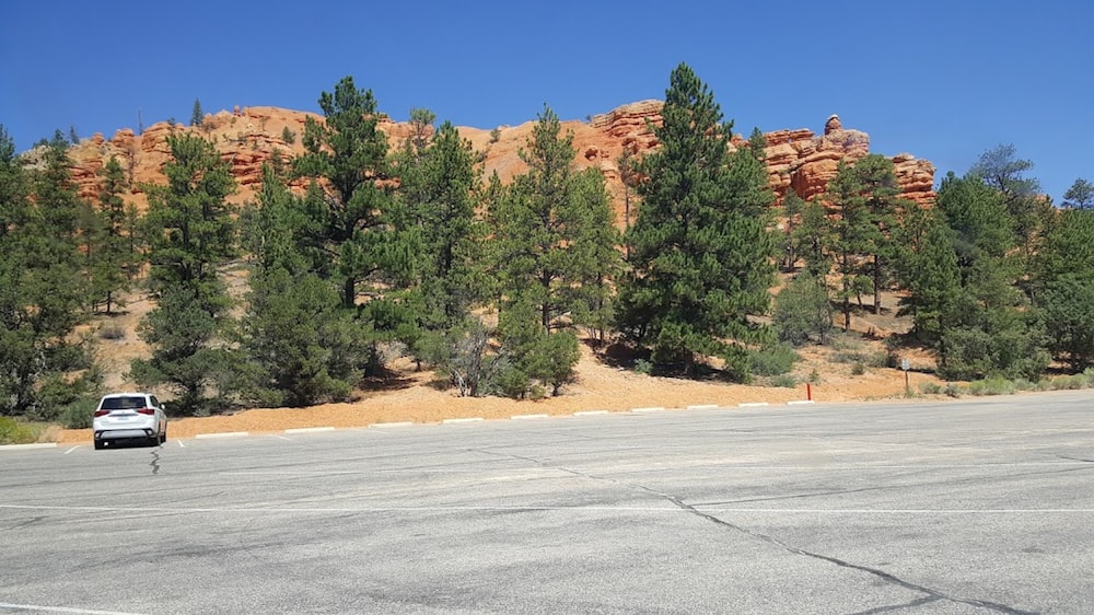 a car parked in a parking lot next to a mountain