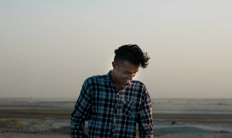 a man standing in front of a body of water