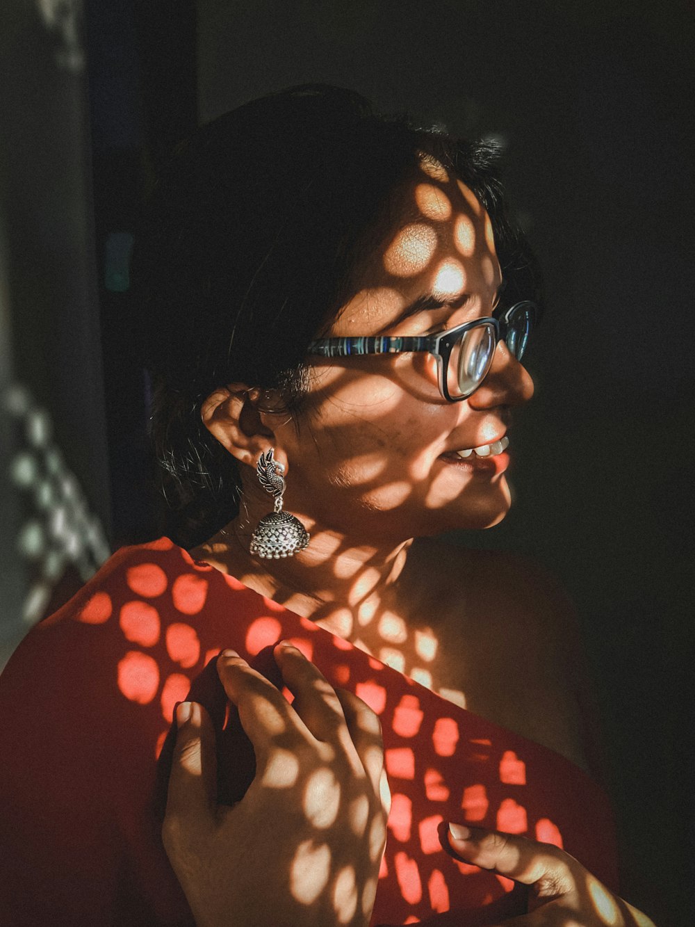 a woman wearing glasses and a red top