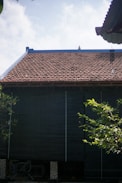 a black building with a red tiled roof