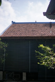 a black building with a red tiled roof
