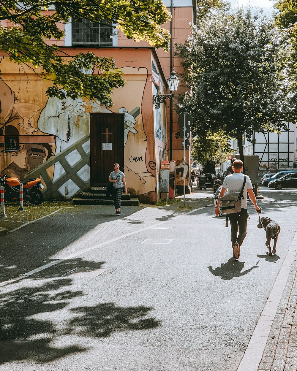 Ein Mann, der mit einem Hund eine Straße entlang führt