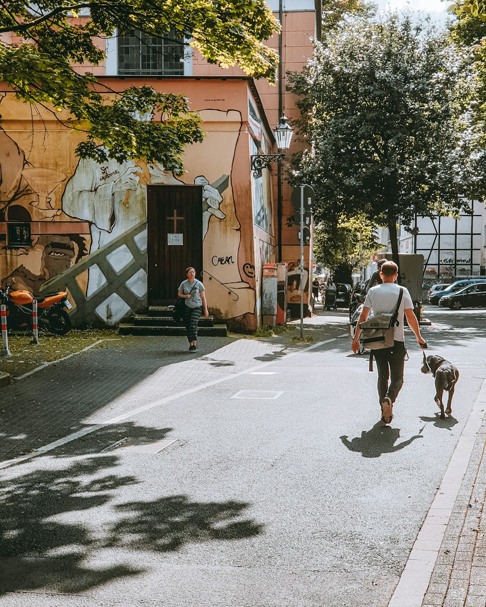 a man walking a dog down a street