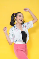 A joyful person wearing bright stockings and metal pins, smiling in a cozy, colorful living space