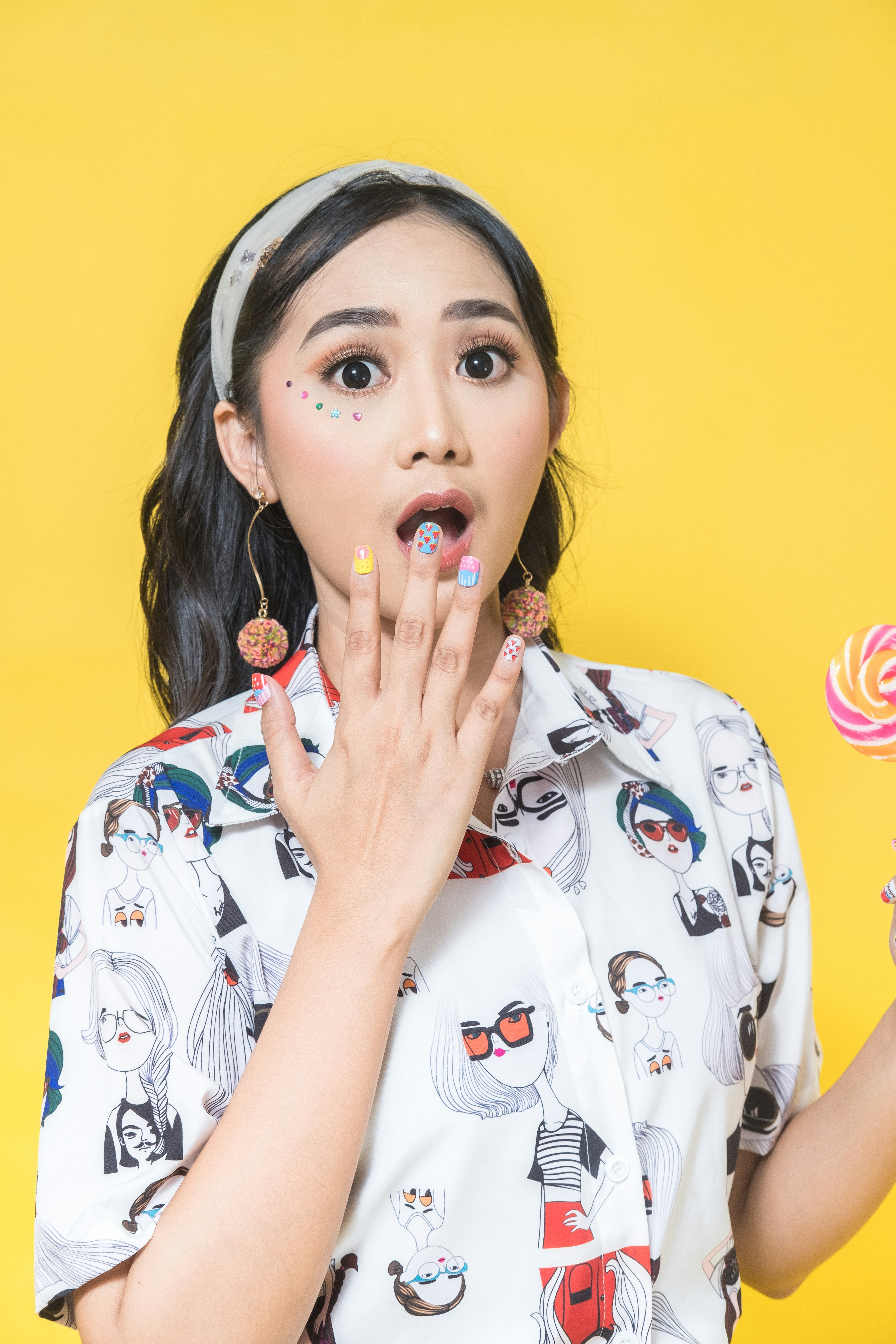 Seorang wanita memegang lolipop dan lolipop di tangannya