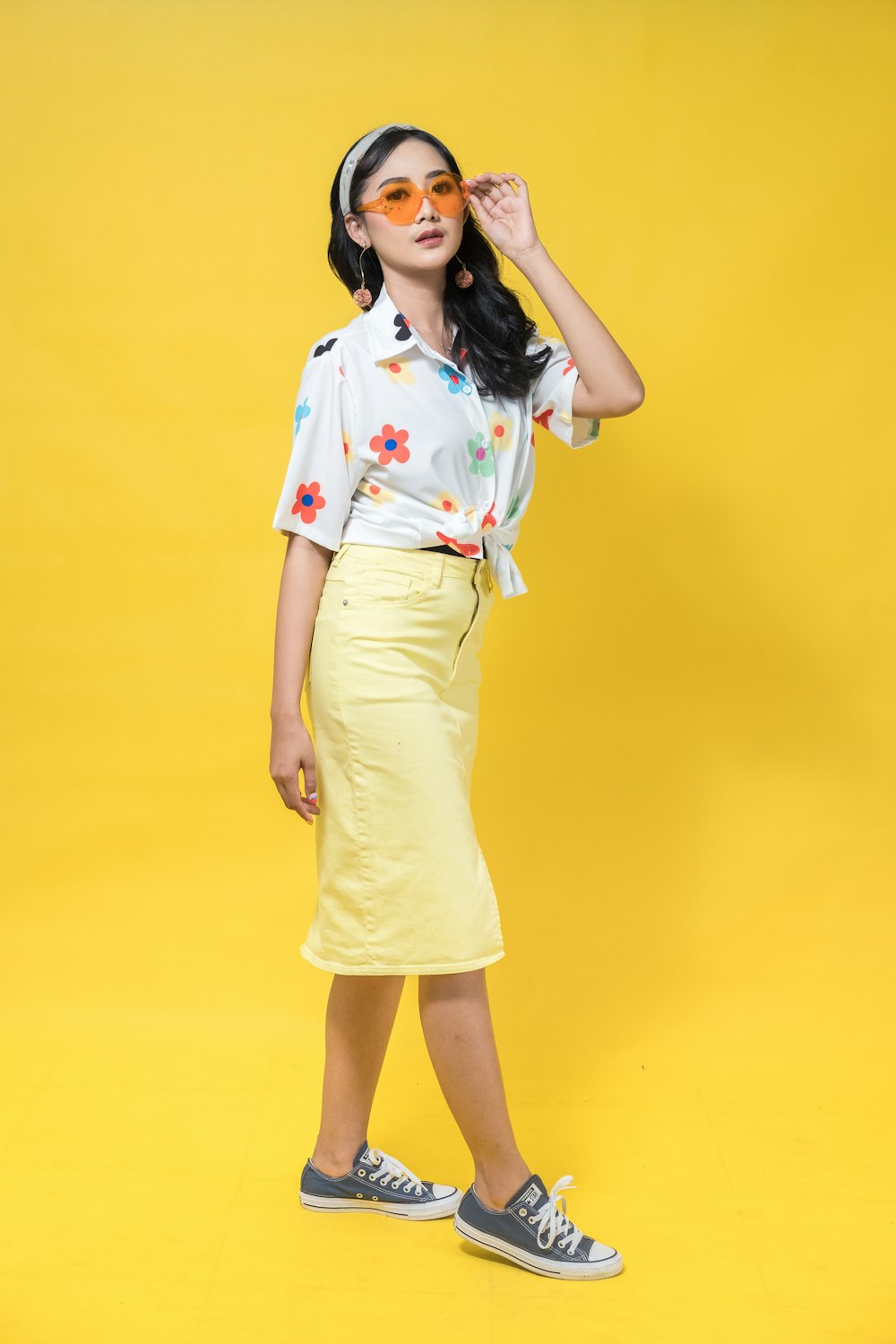 a woman in a white shirt and yellow skirt
