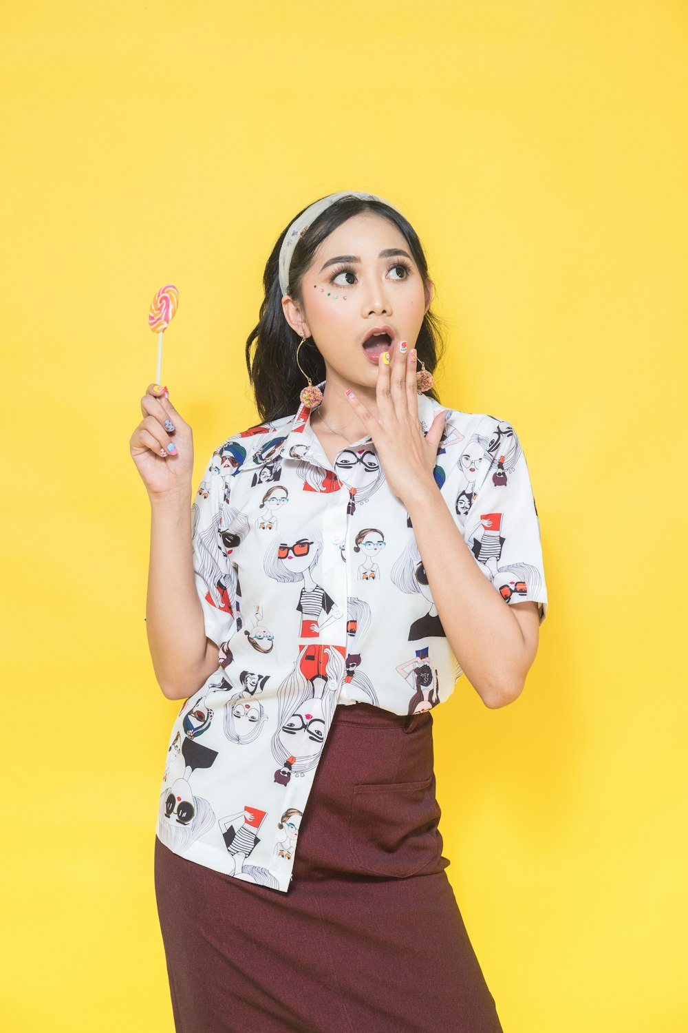 a woman holding a lollipop in her hand