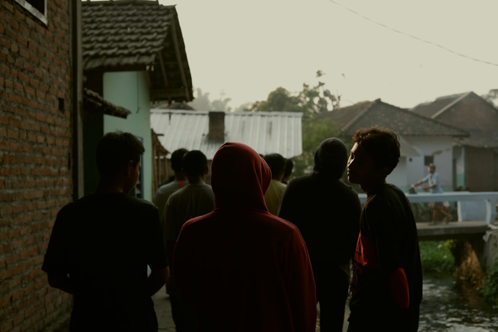 a group of people standing next to a brick building