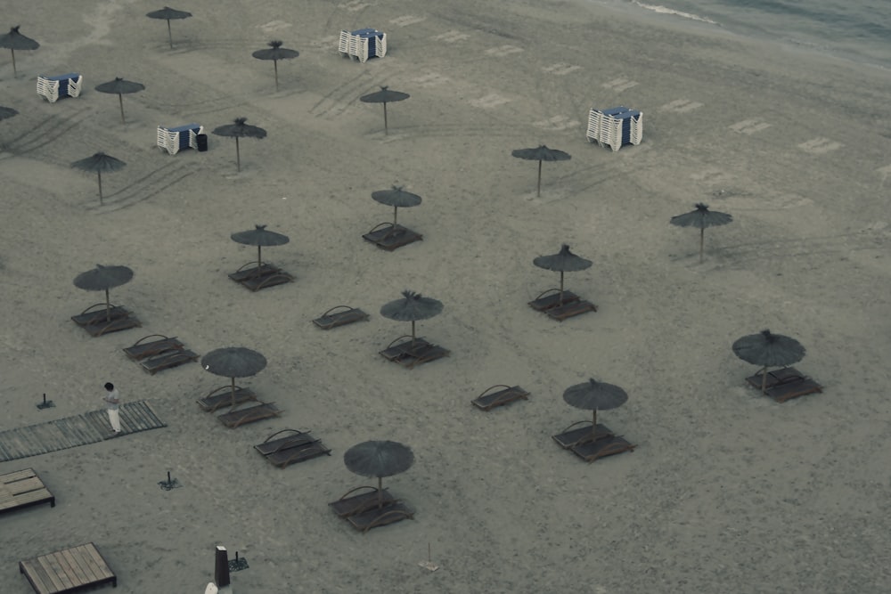 an aerial view of a beach with umbrellas and chairs