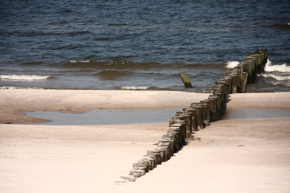 a long wooden breakwater barrier on a beach