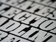 A close-up view of bold, black and white text with a slightly blurred effect, giving the impression of a print or poster design. The letters are large and occupy much of the frame, creating a striking visual impact.