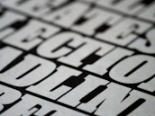 Close-up of oversized typography bleeding off the edge on a stark black background, emphasizing minimalism.