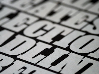 Close-up of black oversized streetwear shirt with bold white text on a minimalist background.
