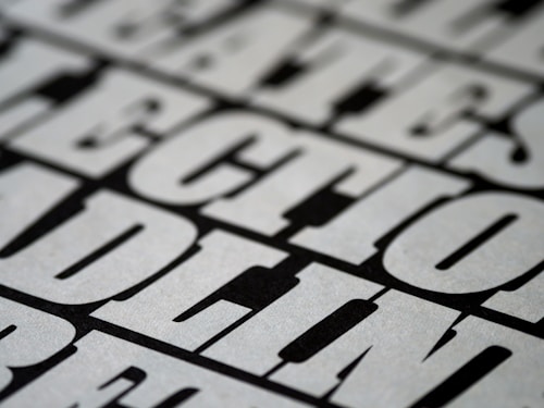 A close-up view of bold, black and white text with a slightly blurred effect, giving the impression of a print or poster design. The letters are large and occupy much of the frame, creating a striking visual impact.