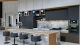 a modern kitchen with marble counter tops and stools