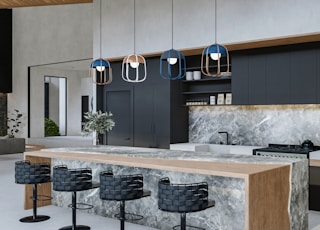 a modern kitchen with marble counter tops and stools