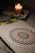 Close-up of a colorful handmade epoxy candle glowing warmly on a wooden table.