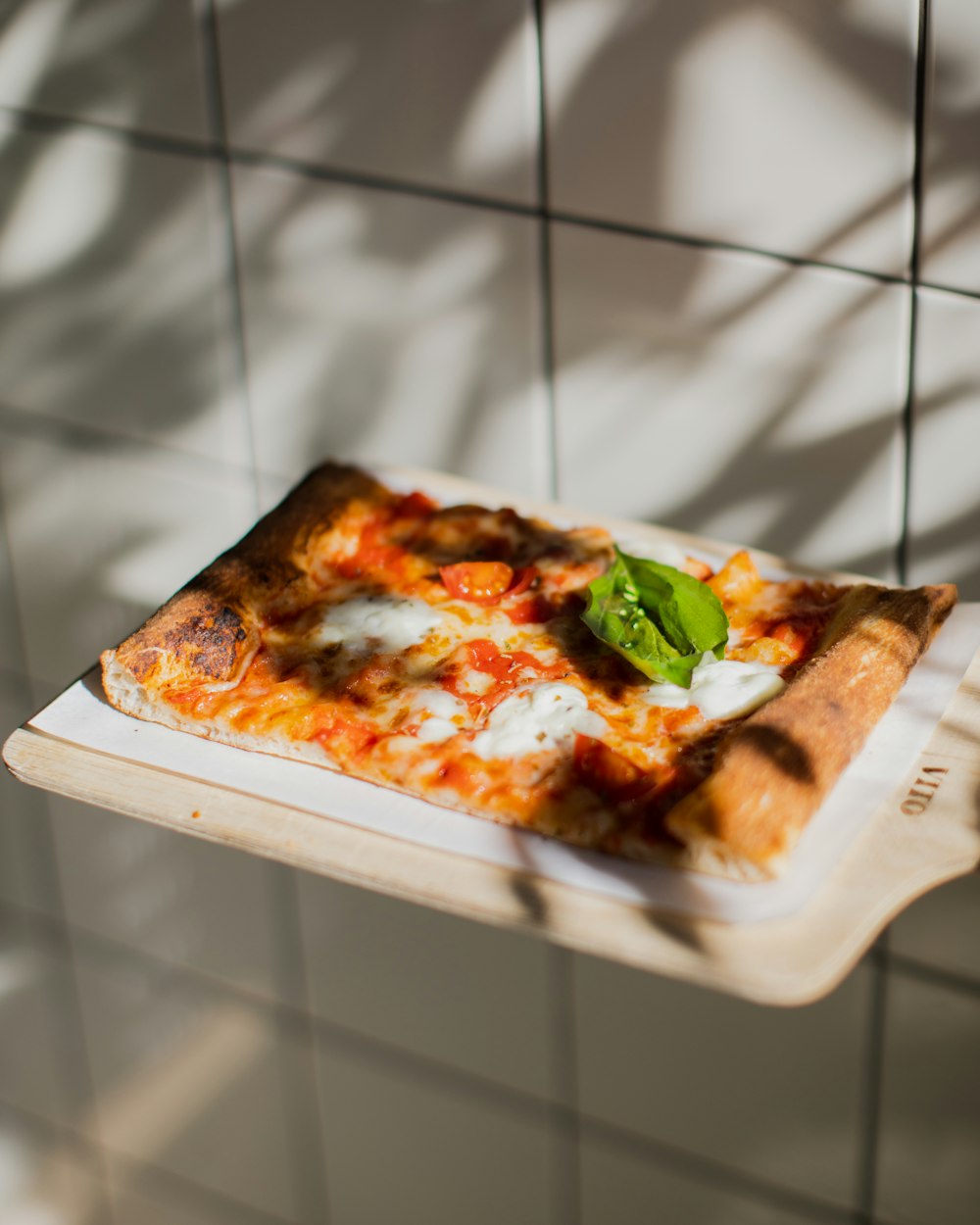 a slice of pizza sitting on top of a cutting board