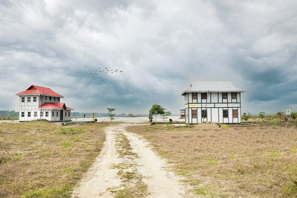 a dirt road in front of a white house