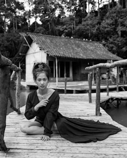 a woman sitting on a dock next to a dog